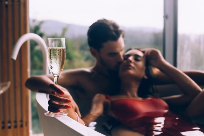 Beautiful couple enjoying a relaxing bath with champagne